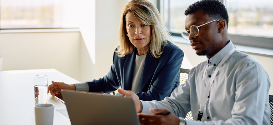 Two insurance agents reviewing work on a computer