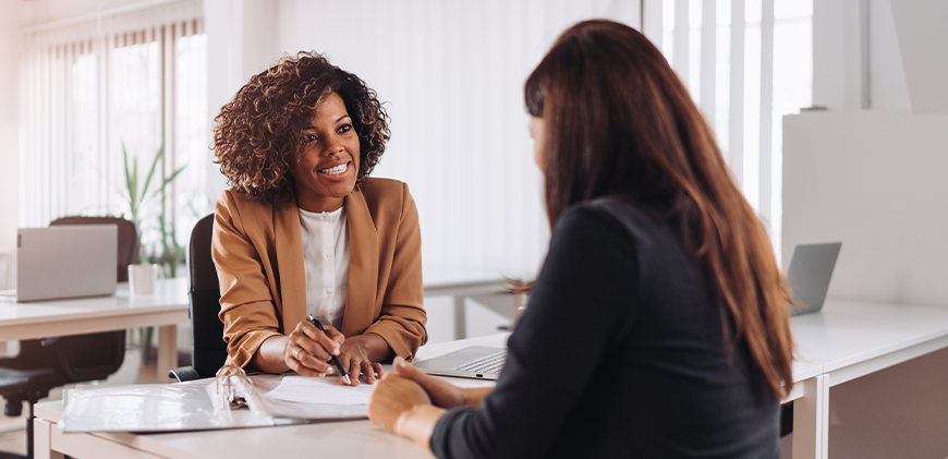 Smiling professional insurance agent helping her client with paperwork