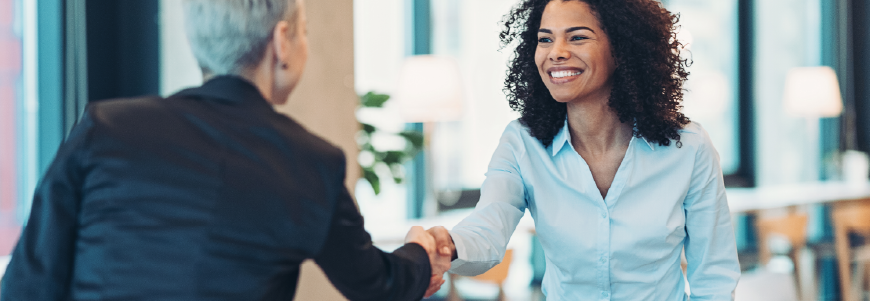 Two women shaking hands in office