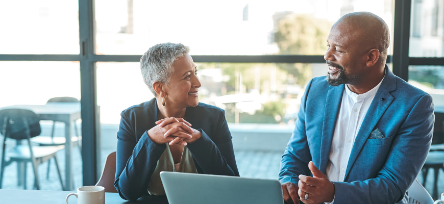 Two insurance professionals happily chatting in the office.