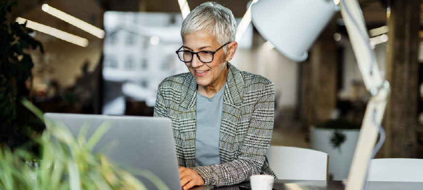 Woman happily working on laptop in office