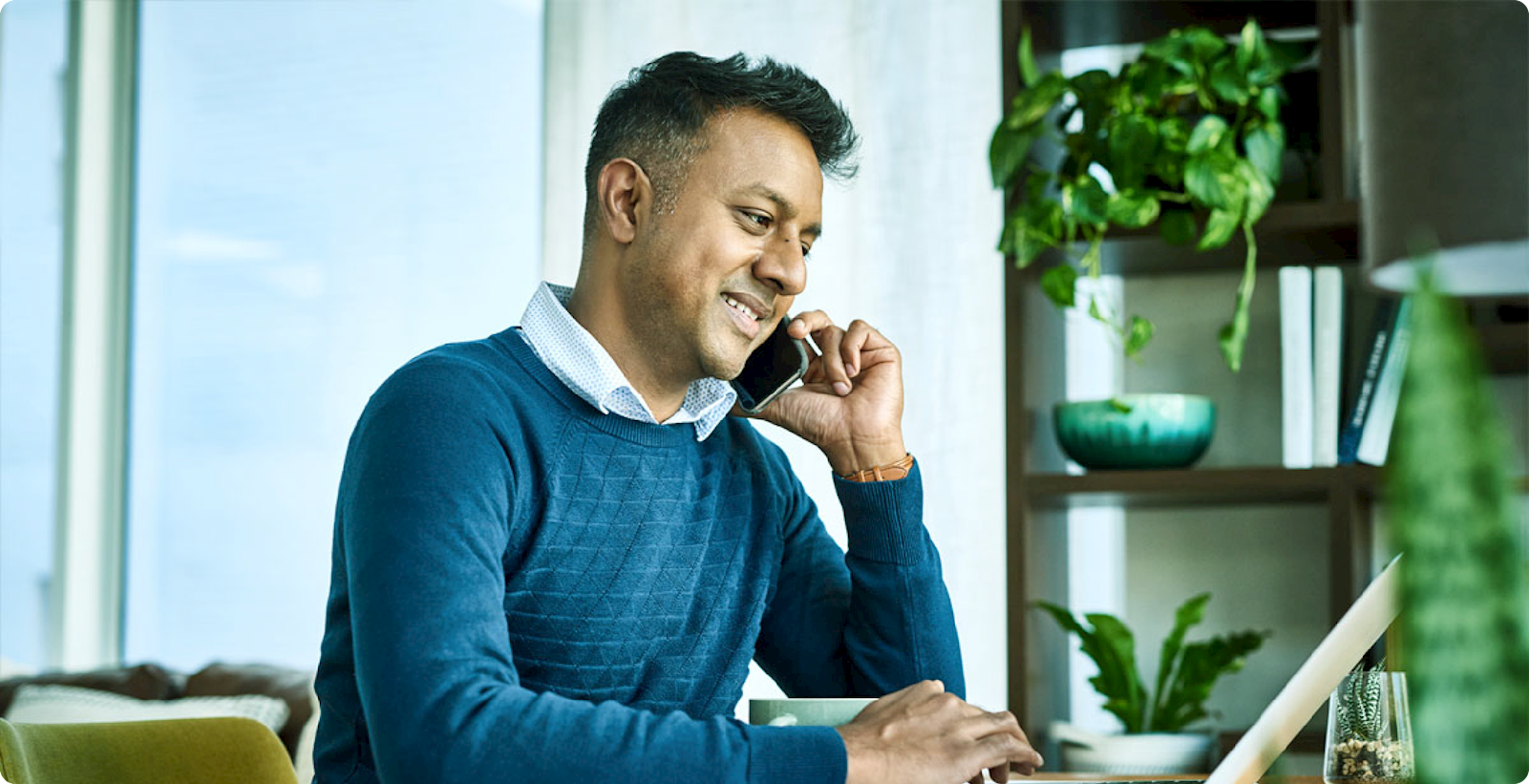 Man talking on phone while on computer